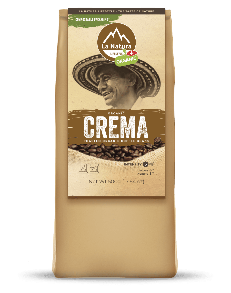 A beige coffee bag labeled "La Natura Lifestyle Organic Crema, Roasted Organic Coffee Beans." The label features a man in a hat, a coffee bean graphic, and text noting compostable packaging and 500g (17.64 oz) weight. The intensity level is shown as 7/10.